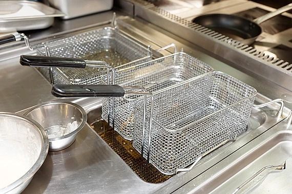 Una canasta para freír está colocada encima de una estufa en una cocina.