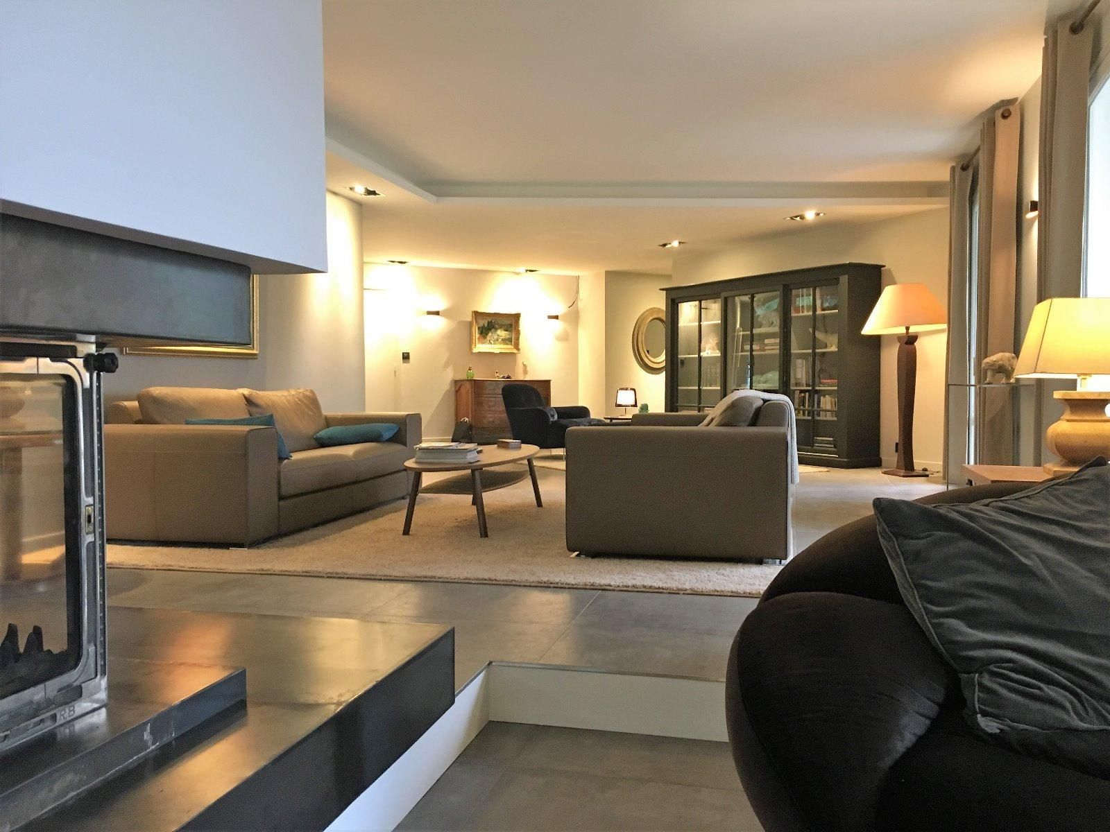 Aménagement d'un salon avec les murs clairs, tapis clair, deux canapés gris…