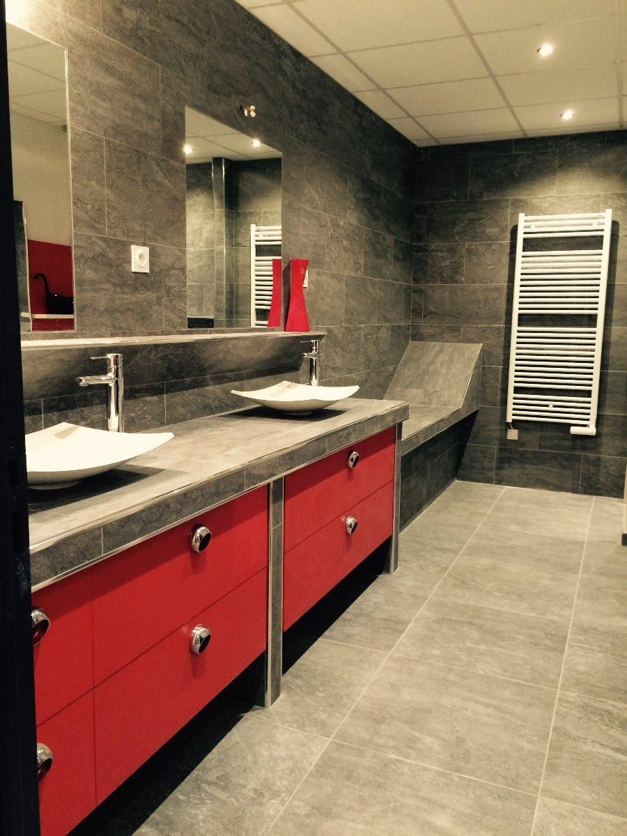 Salle de bains avec carrelage gris, mobilier rouge et deux vasques.