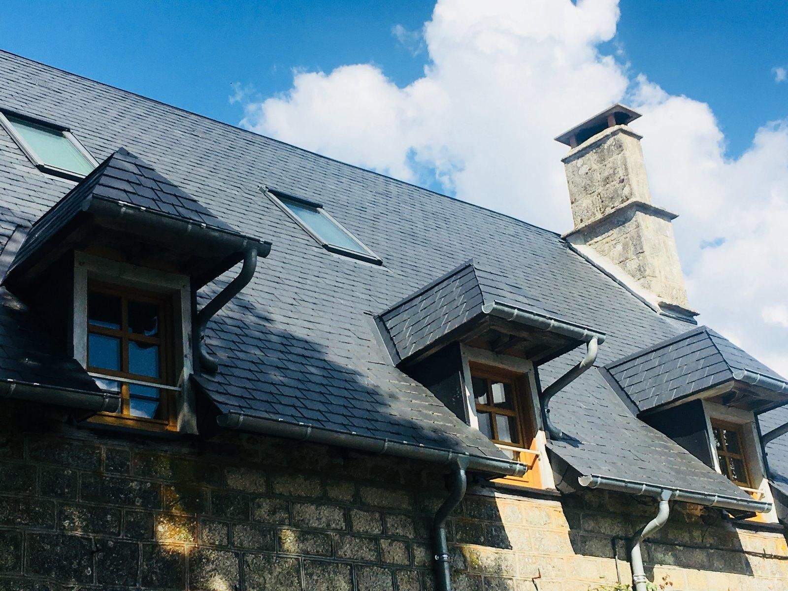 Couverture en ardoise rénovée avec des avancées sur des fenêtres