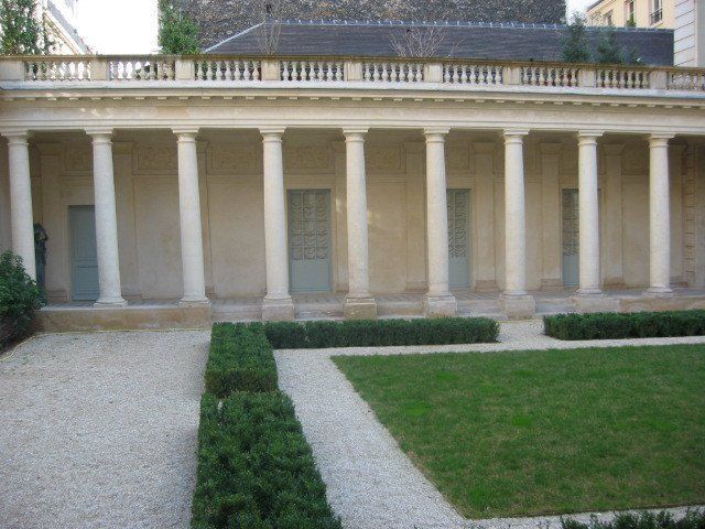 Création d'allées en gravier, séparées de haies en face d'un monument