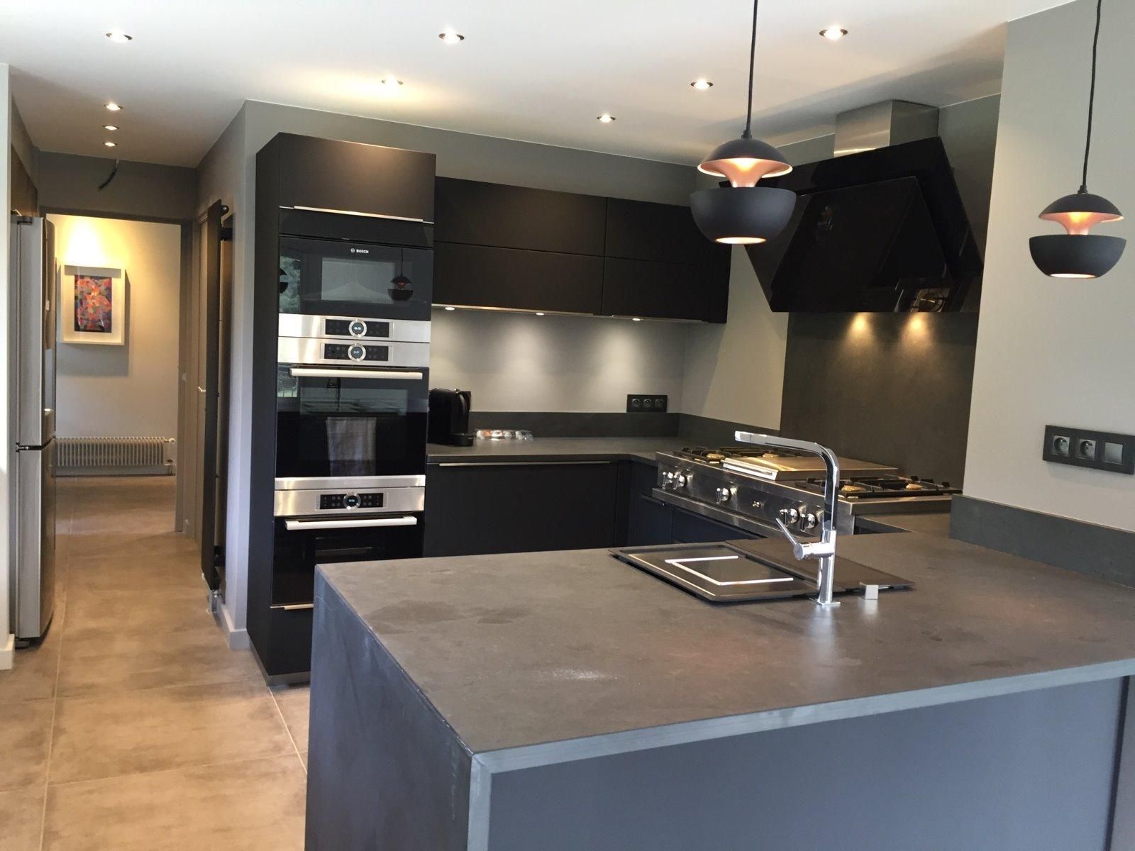 Aménagement d'une cuisine avec un îlot central gris anthracite et un lavabo.