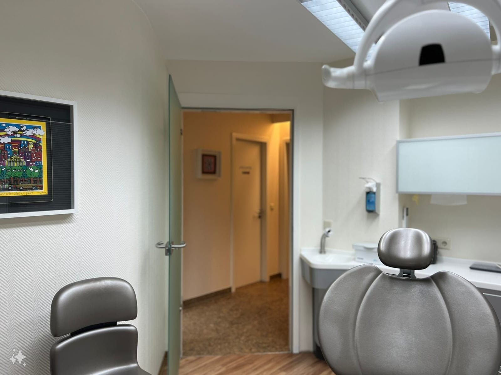 Behandlungsraum mit weißer und silberner Ausstattung in der Zahnarztpraxis Jürgen Dreiling