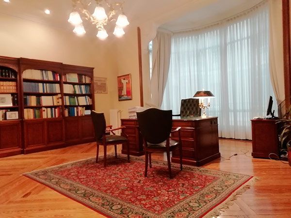 Una habitación con una alfombra, un escritorio y sillas.