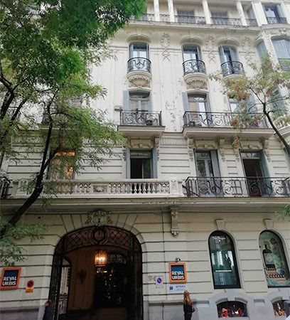 Un gran edificio blanco con muchas ventanas y balcones.