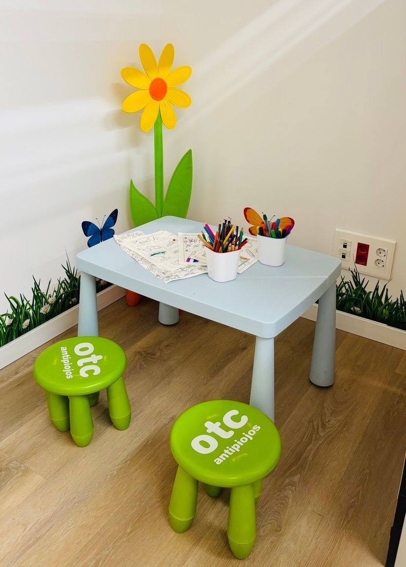 Una mesa para niños con una flor y dos taburetes que dicen otc