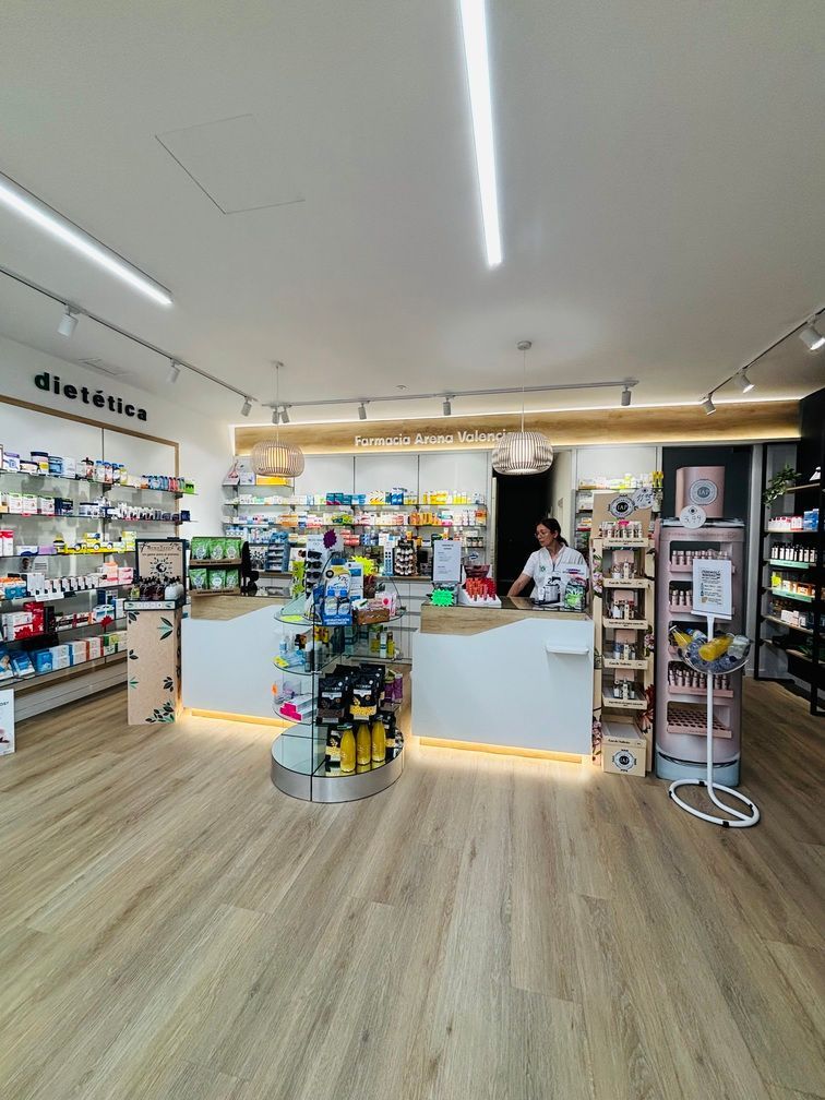 Una mujer está parada en un mostrador en una farmacia.