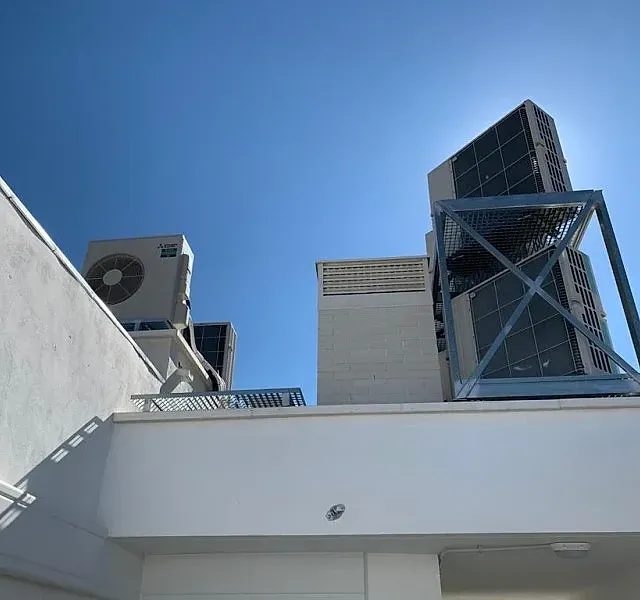 Mirando hacia arriba a un edificio con un cielo azul en el fondo