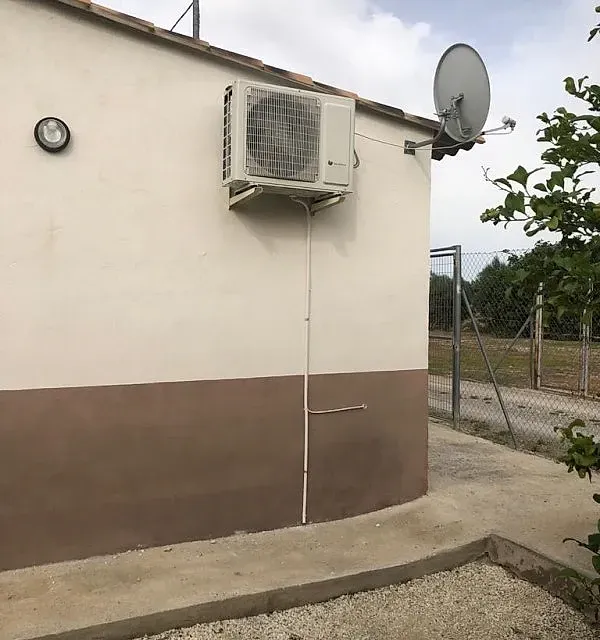 Hay una antena parabólica en el costado del edificio.