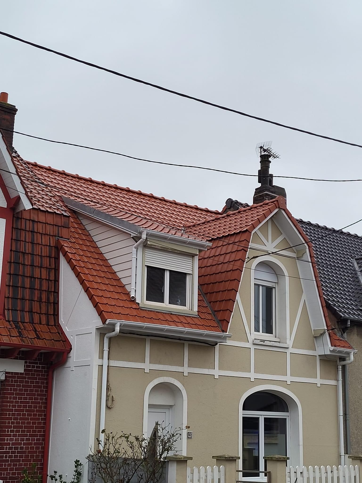 Maison mitoyenne avec toit en tuiles couleur brique et façade à colombage