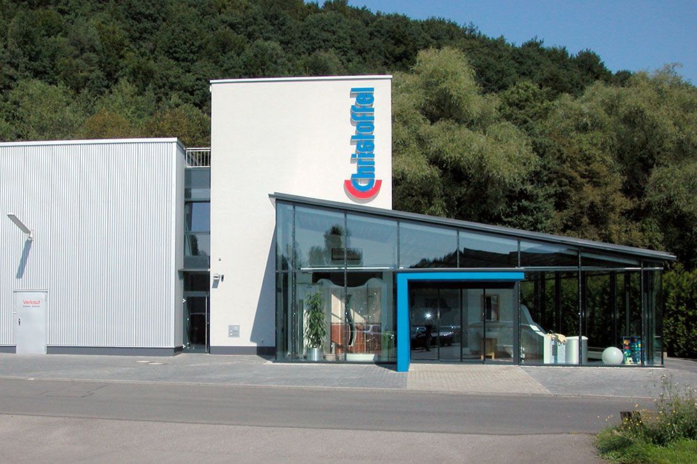 Ein großes weißes Gebäude mit einem blauen Schild mit der Aufschrift 