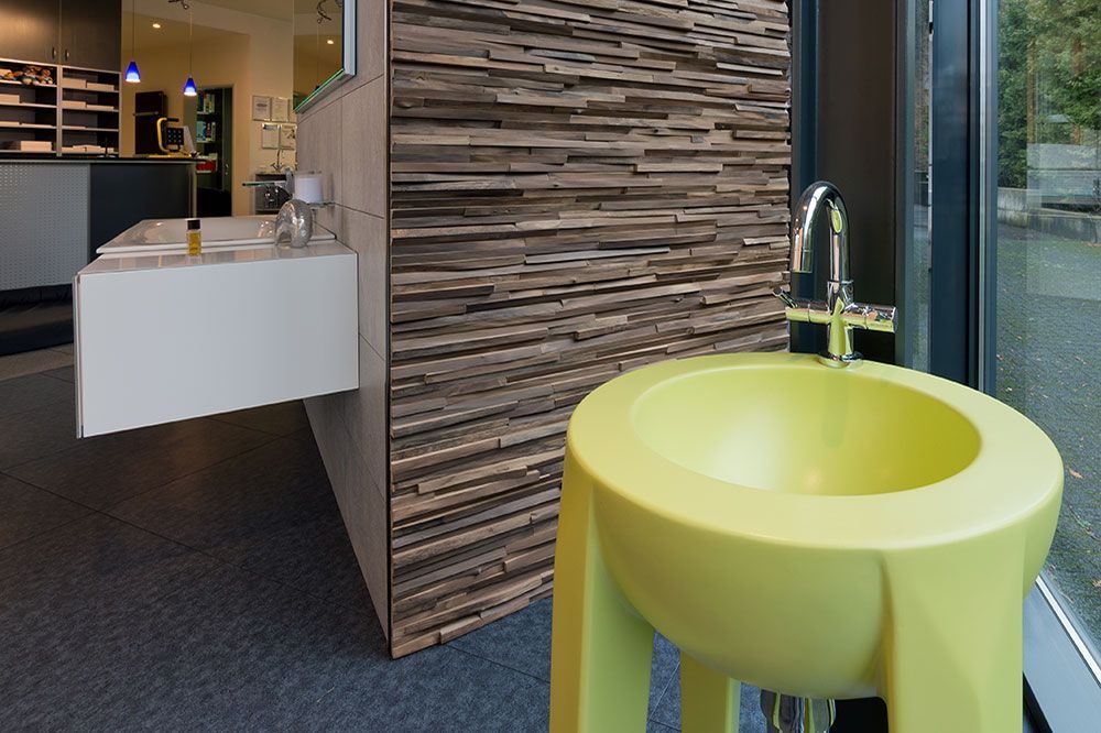 Ein gelbes Waschbecken in einem Badezimmer neben einem Fenster