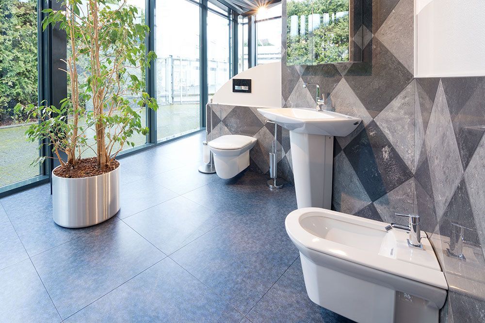 Ein Badezimmer mit Toiletten, Waschbecken und Bidet