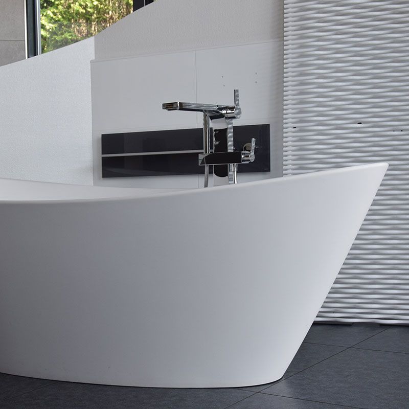 Eine weiße Badewanne mit einem Chromhahn in einem Badezimmer