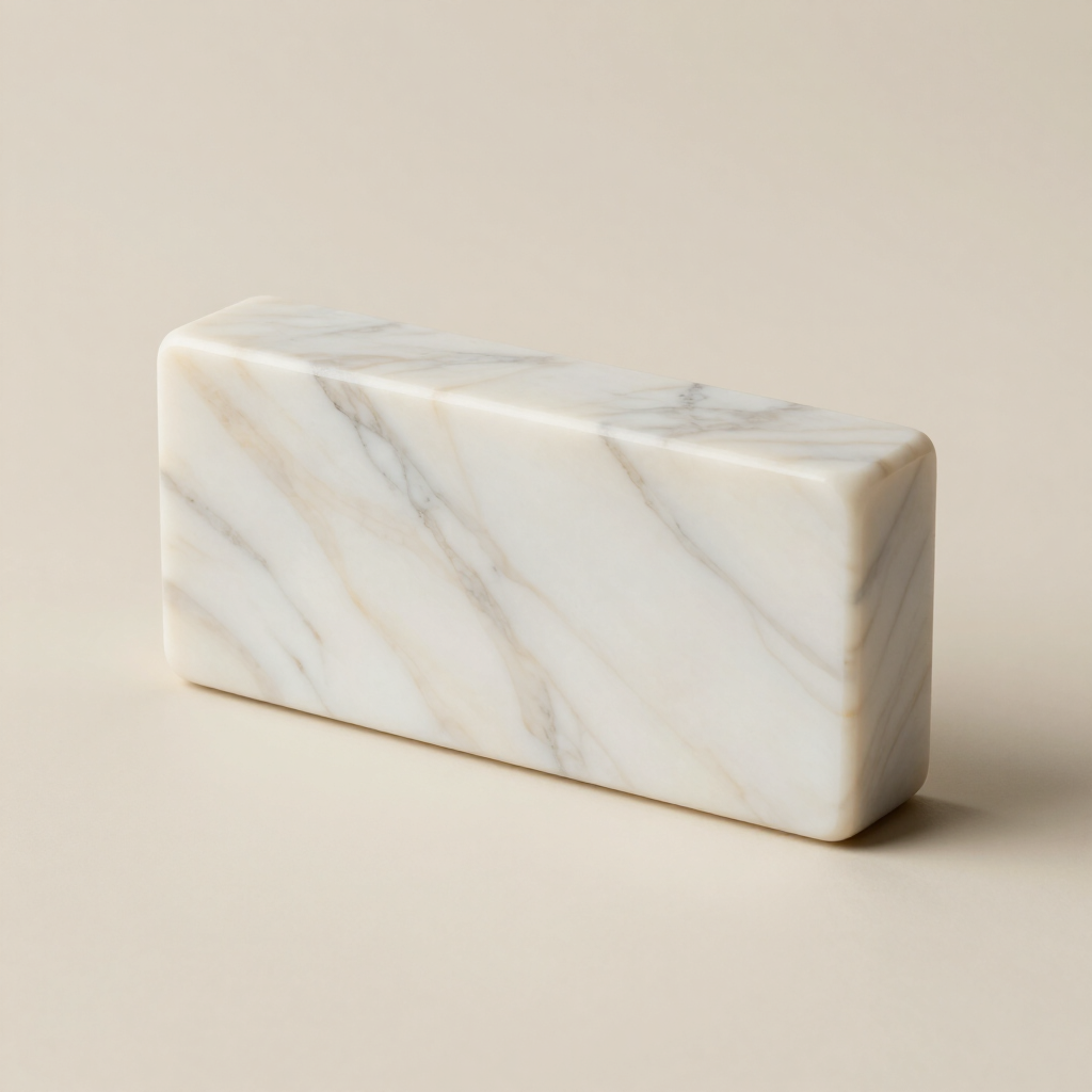 Bloque rectangular de mármol blanco con sutiles vetas grises sobre un fondo beige.