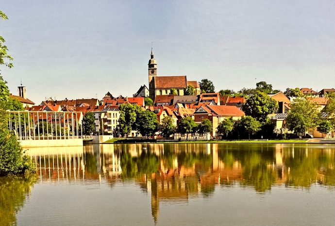 Eine kleine Stadt spiegelt sich im Wasser eines Sees