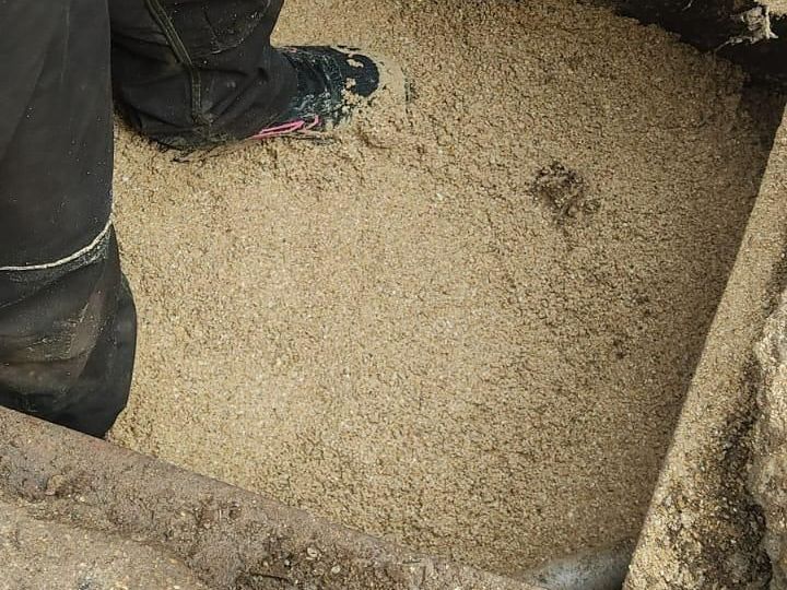 Les pieds du professionnel dans une cuve remplie de sable.