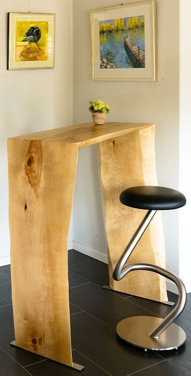 Ein Holztisch mit einem schwarzen Hocker daneben