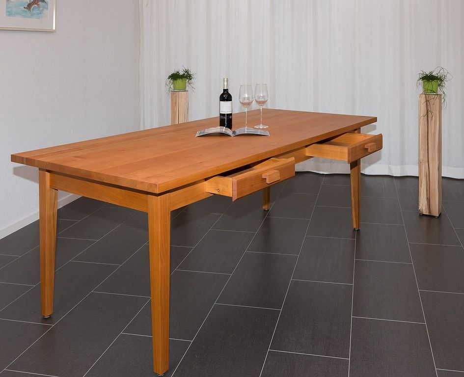 Ein Holztisch mit einer Flasche Wein und zwei Gläsern darauf