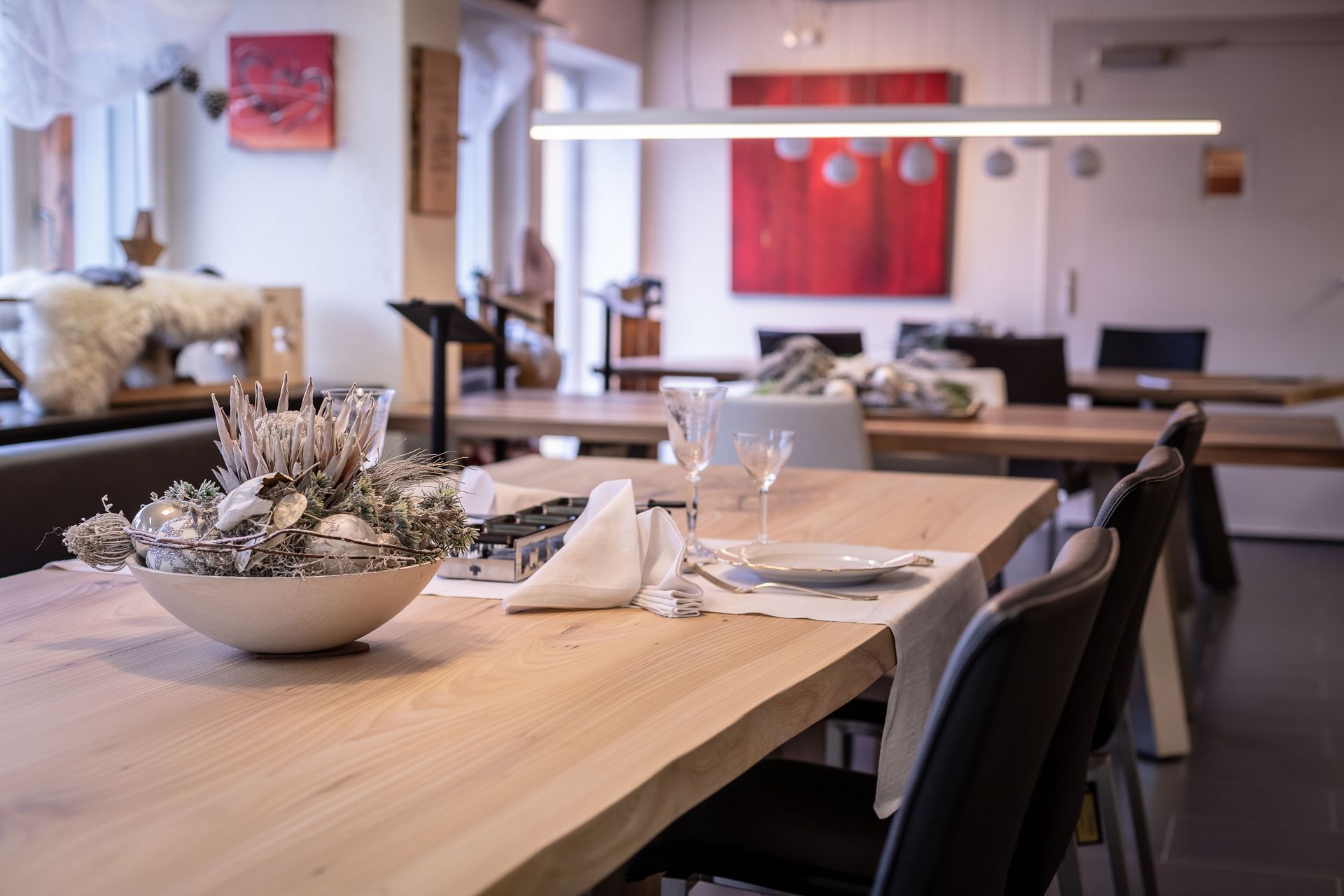 Ein Esstisch mit einer Schale Blumen darauf.