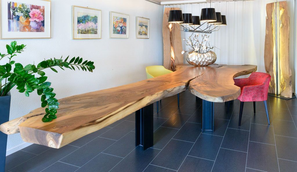 Ein Esszimmer mit einem langen Holztisch und Stühlen.