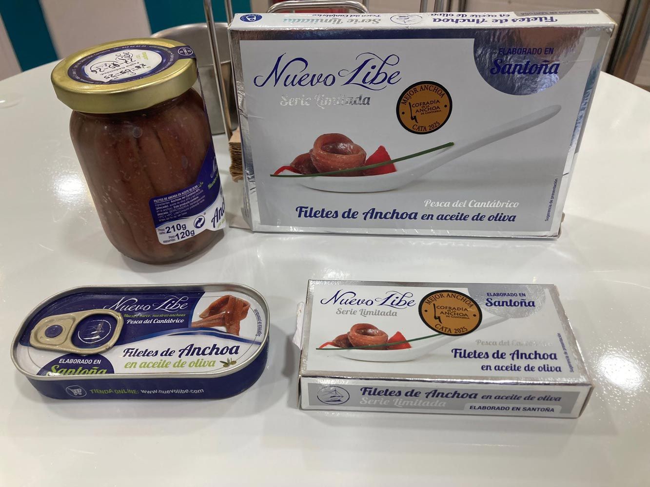 Un tarro de anchoas, una lata de anchoas y una caja de anchoas están sobre una mesa.