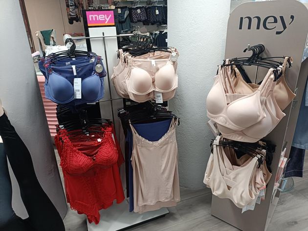 Lingerie display in a store, with bras and underwear of various colors arranged on racks.