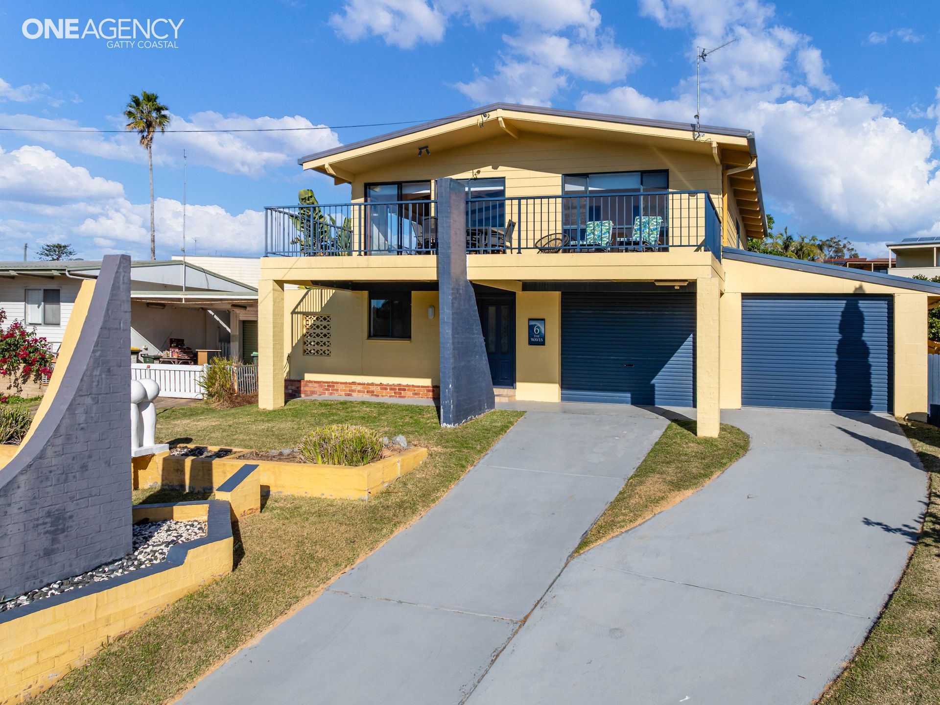 Front exterior and balcony of The Waves, a two-level holiday home in Tuross Head.