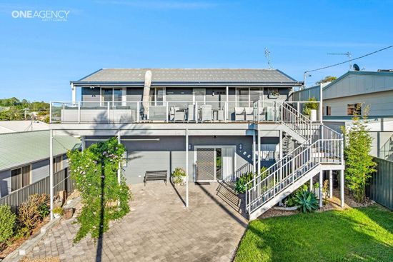 Whale Watcher @ Tuross Head - Two-story house with a , balcony, and front stairs in a sunny Tuross Head yard.