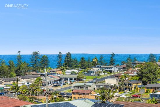 Whale Watcher @ Tuross Head - Coastal town with houses and trees under a clear blue sky beside the ocean