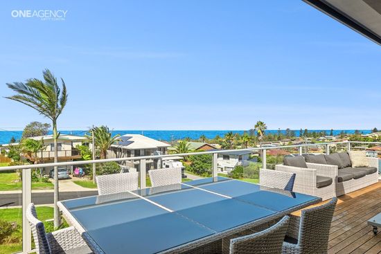 Whale Watcher @ Tuross Head - Oceanfront patio with outdoor seating, palm trees, and a clear blue sky over the sea