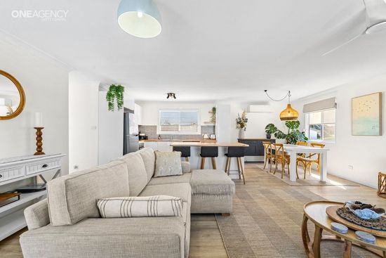 Whale Watcher @ Tuross Head - Bright open living-dining room with beige sectional sofa, and kitchen in the background