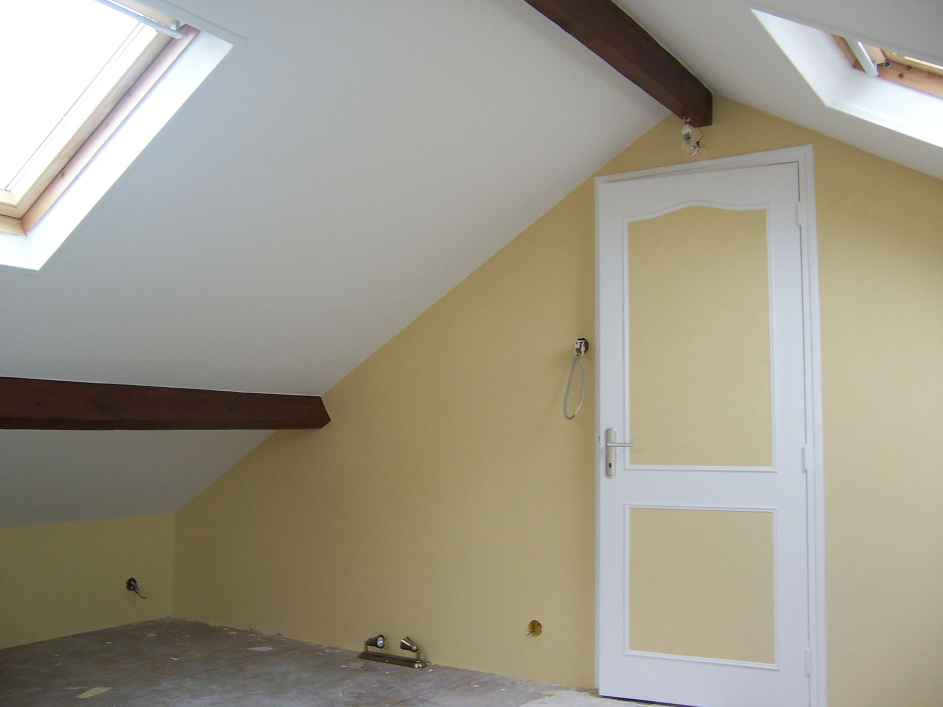 Photo d'une pièce sous un toit avec un mur jaune