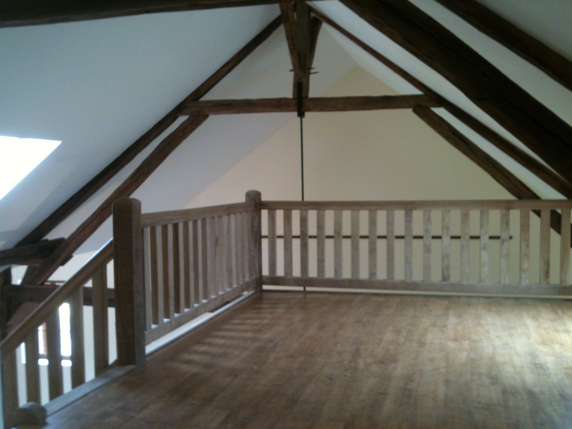 Photo d'un parquet sur une mezzanine avec poutres apparentes