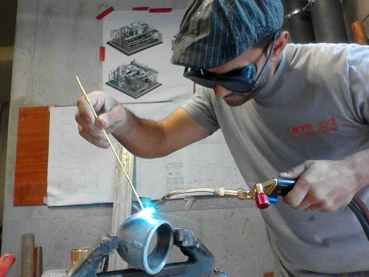 Alphonse Cortes soudant un système de plomberie.