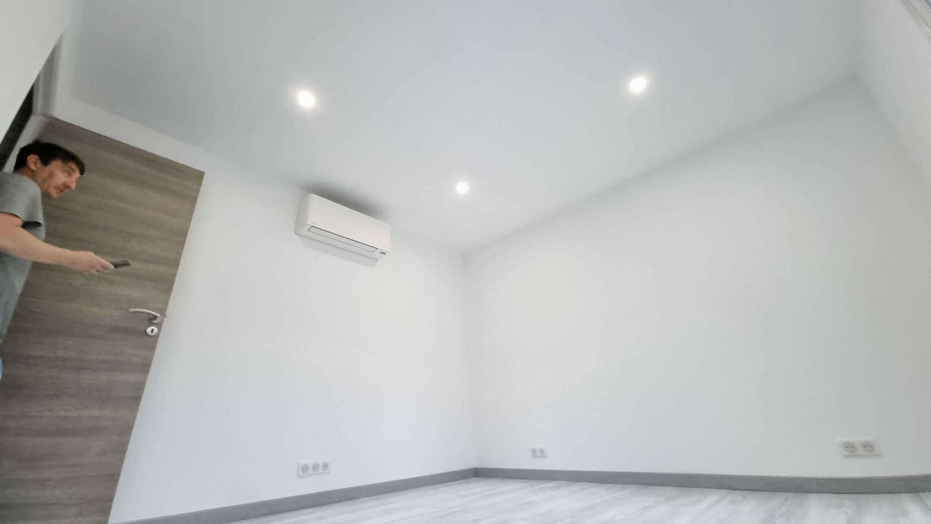 Une pièce aux murs blancs avec des lumières.