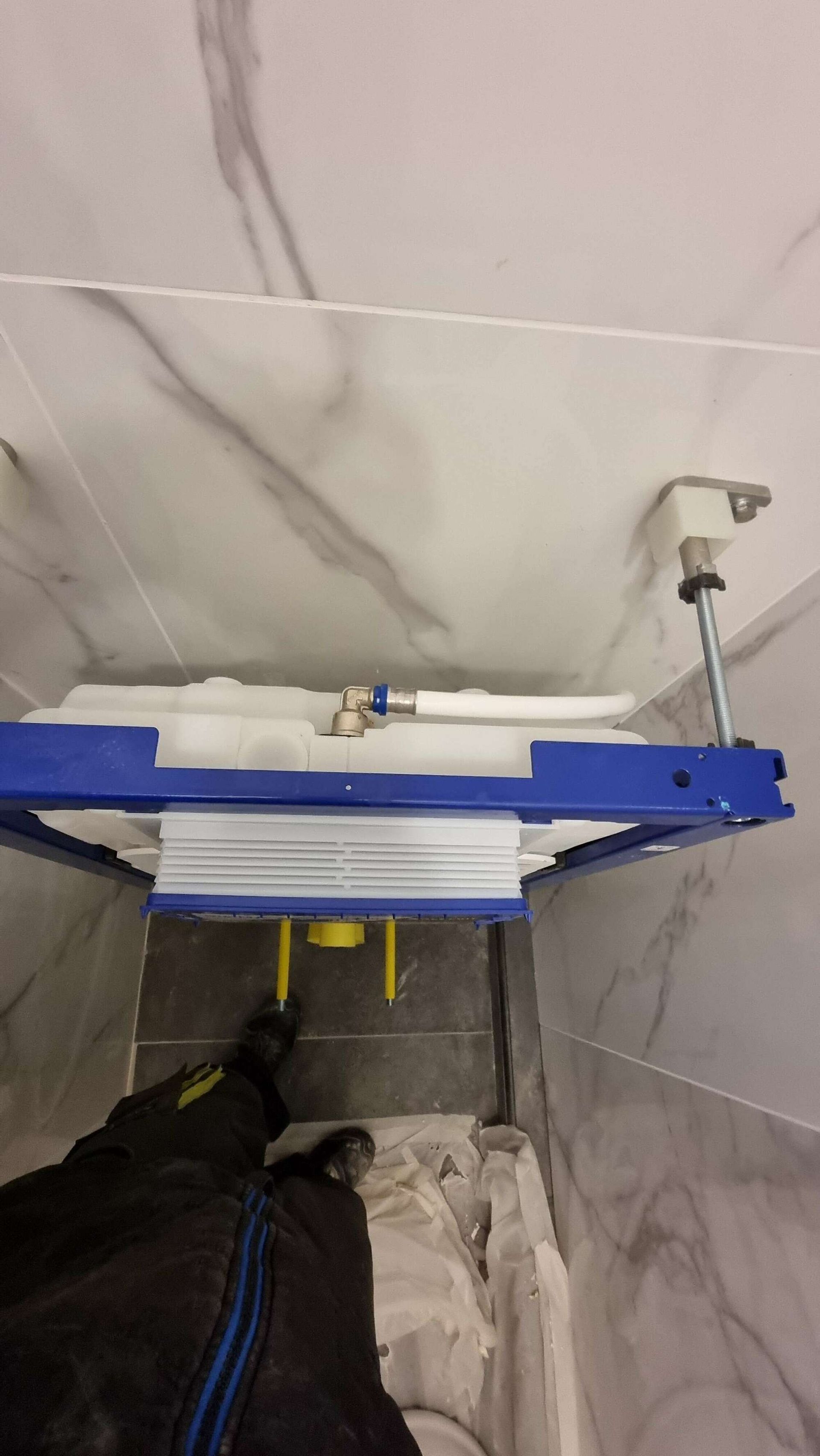 Installation d'une chasse d'eau pour les sanitaires d'une maison.