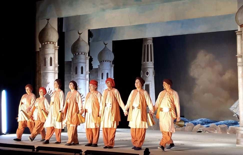 Eine Gruppe von Menschen steht auf einer Bühne und hält sich an den Händen