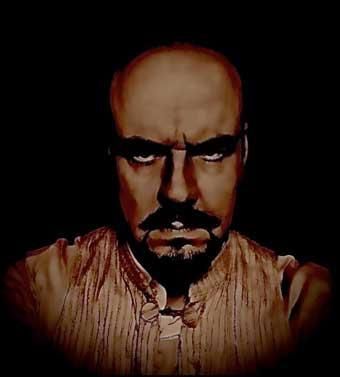 Ein kahlköpfiger Mann mit Bart schaut in einem dunklen Raum in die Kamera.