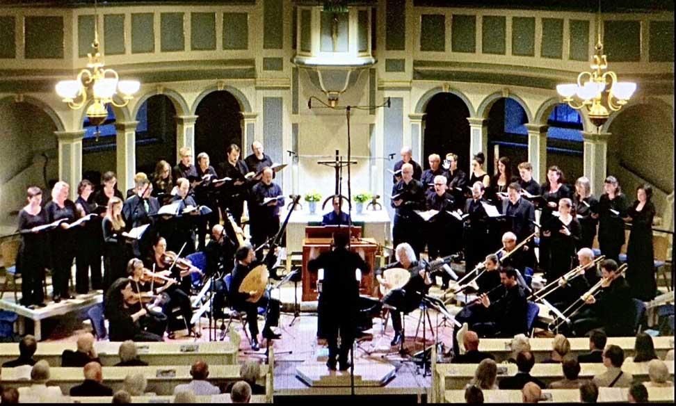 Ein Chor und ein Orchester treten in einer Kirche auf
