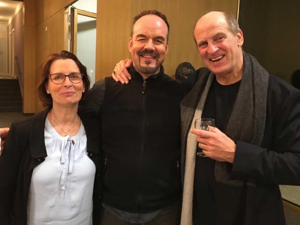 Zwei Männer und eine Frau posieren zusammen für ein Foto