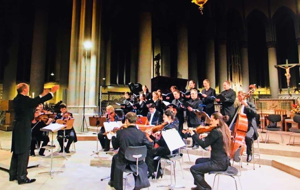 Ein Orchester tritt in einer Kirche mit einem Dirigenten auf