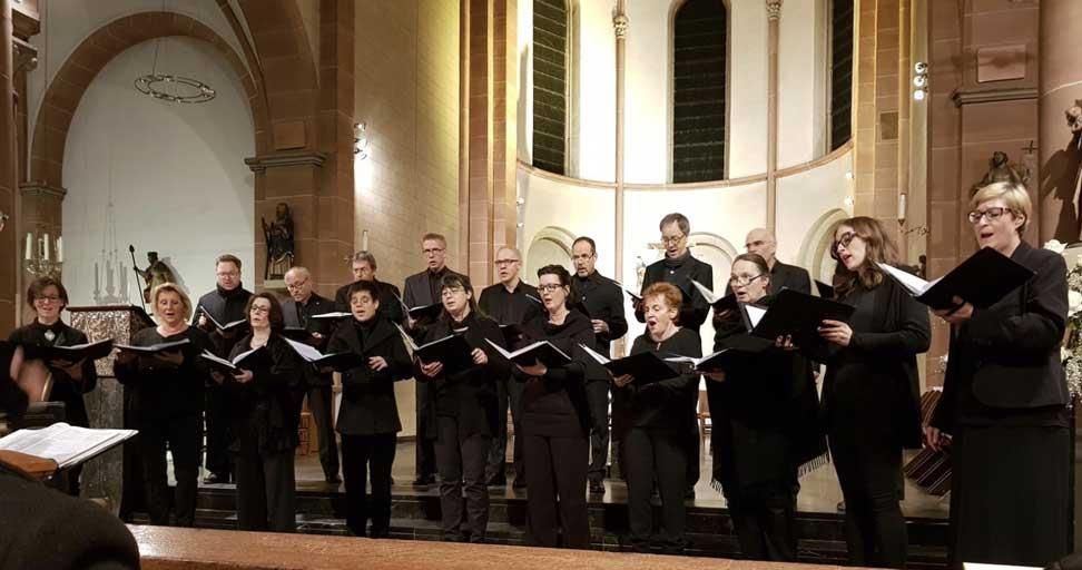 Eine große Gruppe von Menschen singt in einer Kirche.