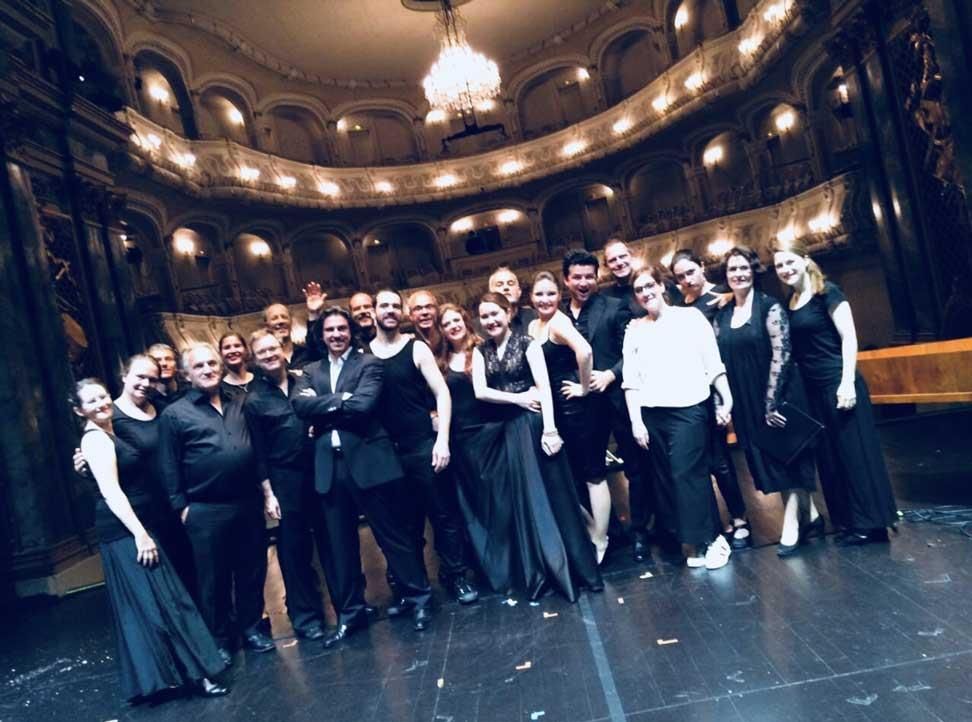 Eine Gruppe von Menschen posiert auf einer Bühne für ein Foto.