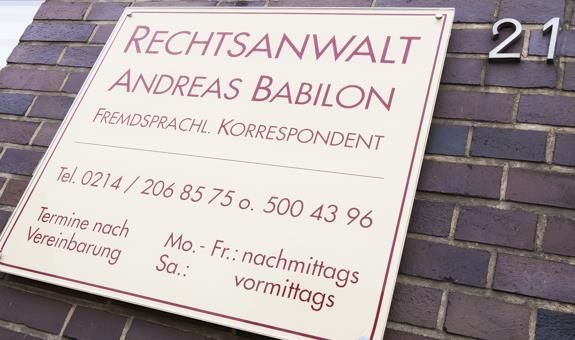 Ein Schild für Andreas Babilon ist auf einer Ziegelmauer