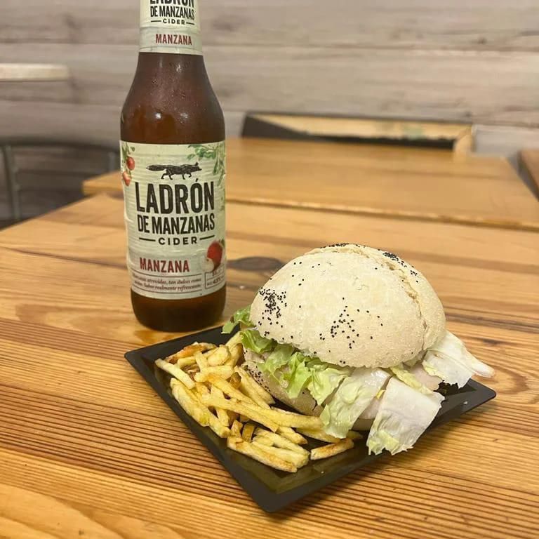 Una botella de Ladrón de manzanas se encuentra junto a un plato de comida.