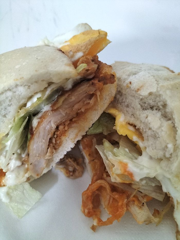 Un sándwich se corta por la mitad en un plato blanco.