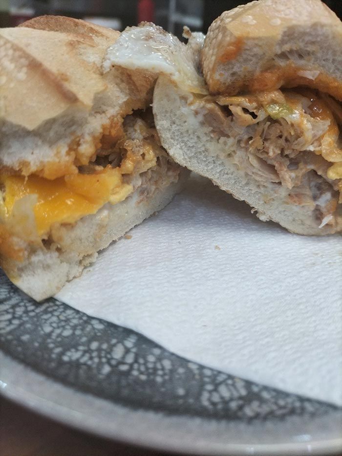 Un primer plano de un sándwich en un plato sobre una servilleta.
