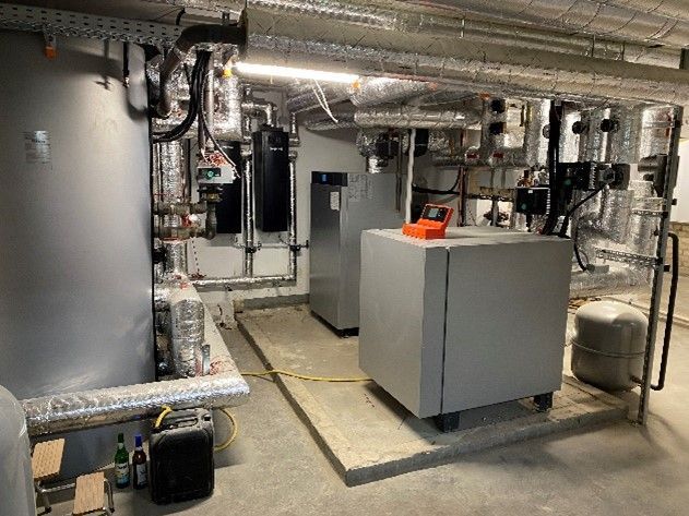 Ein Raum mit vielen Kesseln und Rohren darin.