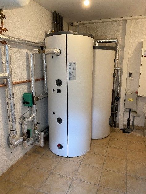 In einem Raum stehen zwei weiße Warmwasserbereiter nebeneinander.